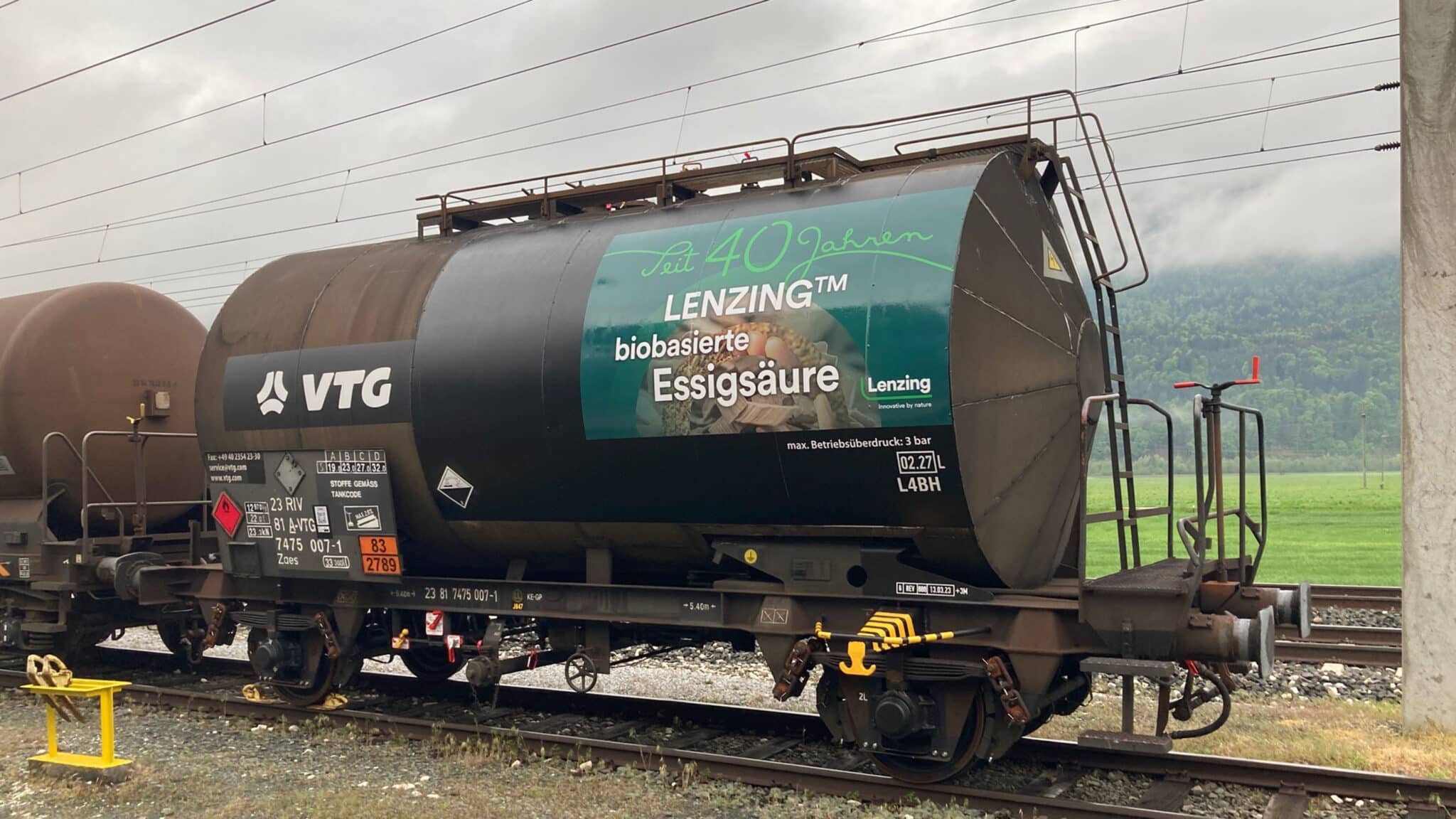 Tank car with the lettering "For 40 years LENZING™ bio-based acetic acid" stands on tracks.